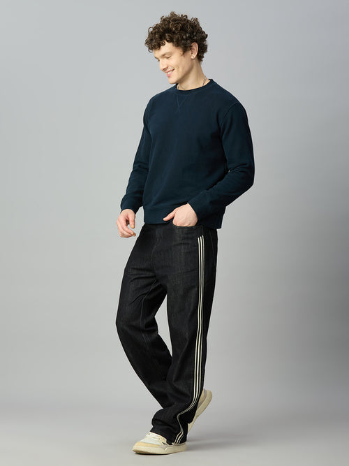 Model wearing The Lofa men's raw black baggy denim jeans with double side stripes for a premium streetwear look