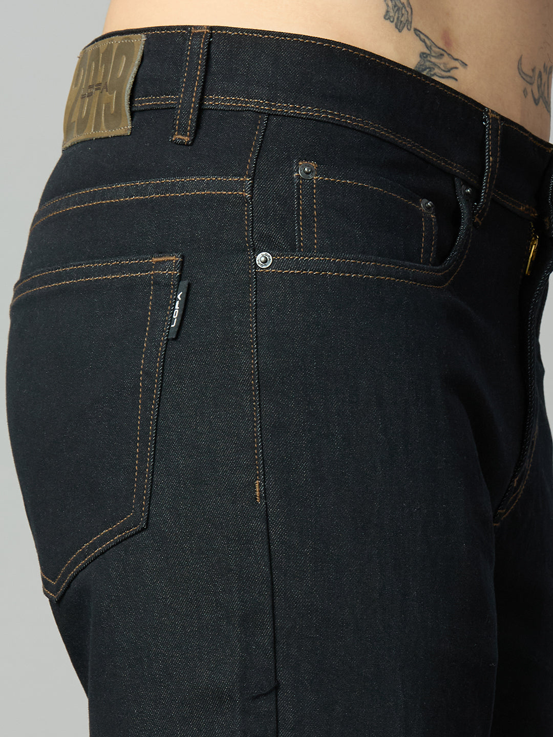 Close-up of button closure, zip fly, and premium waistband on men's bootcut denim jeans