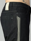 Close-up of waistband, button closure, and premium raw black denim on men's baggy jeans