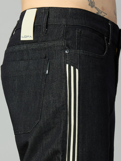 Close-up of waistband, button closure, and premium raw black denim on men's baggy jeans