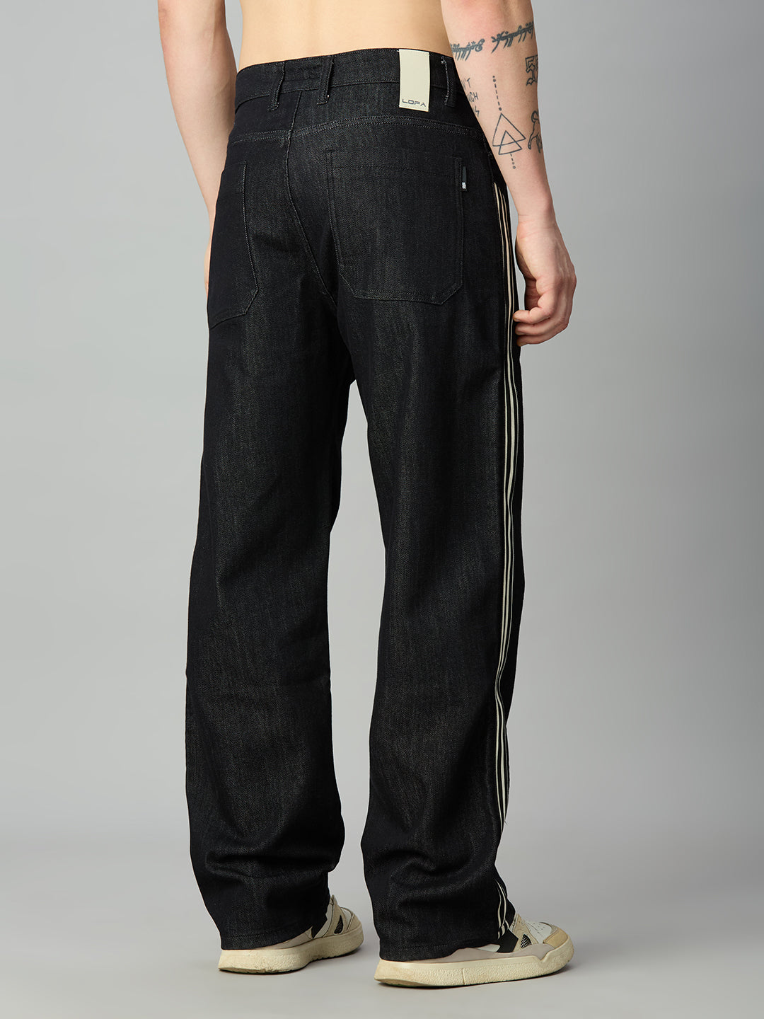 Men's raw black baggy denim jeans with classic back pockets and side stripes – back view
