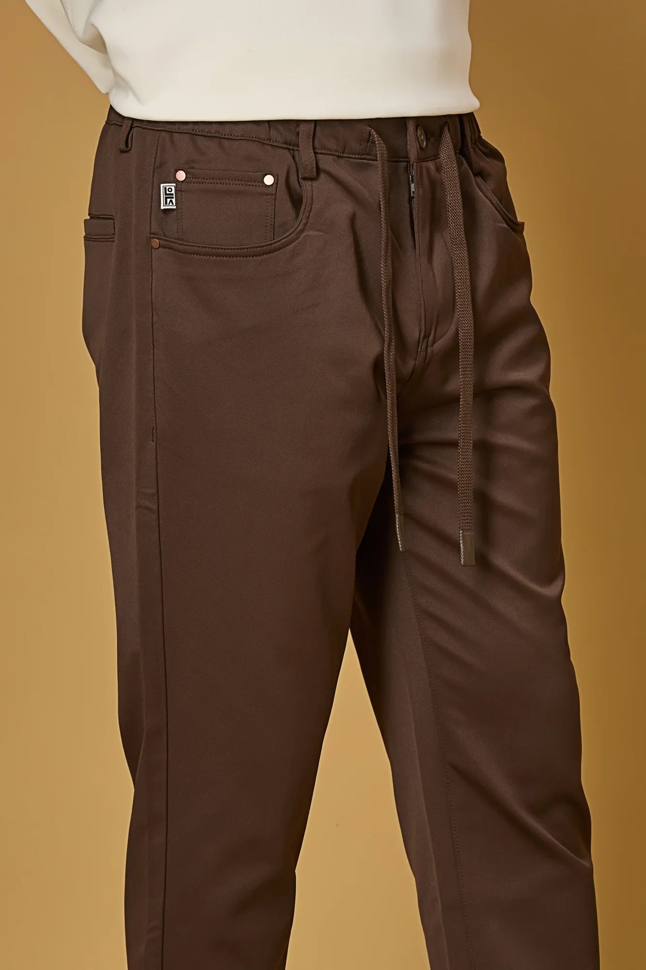 Close-up of Coffee Brown polyester fabric texture showing smooth and stretchable finish.