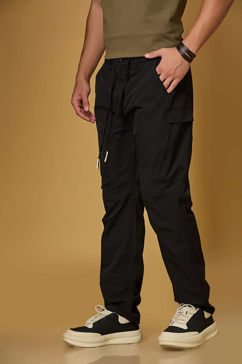 Black stretchable trousers side view showing two side pockets and relaxed fit.