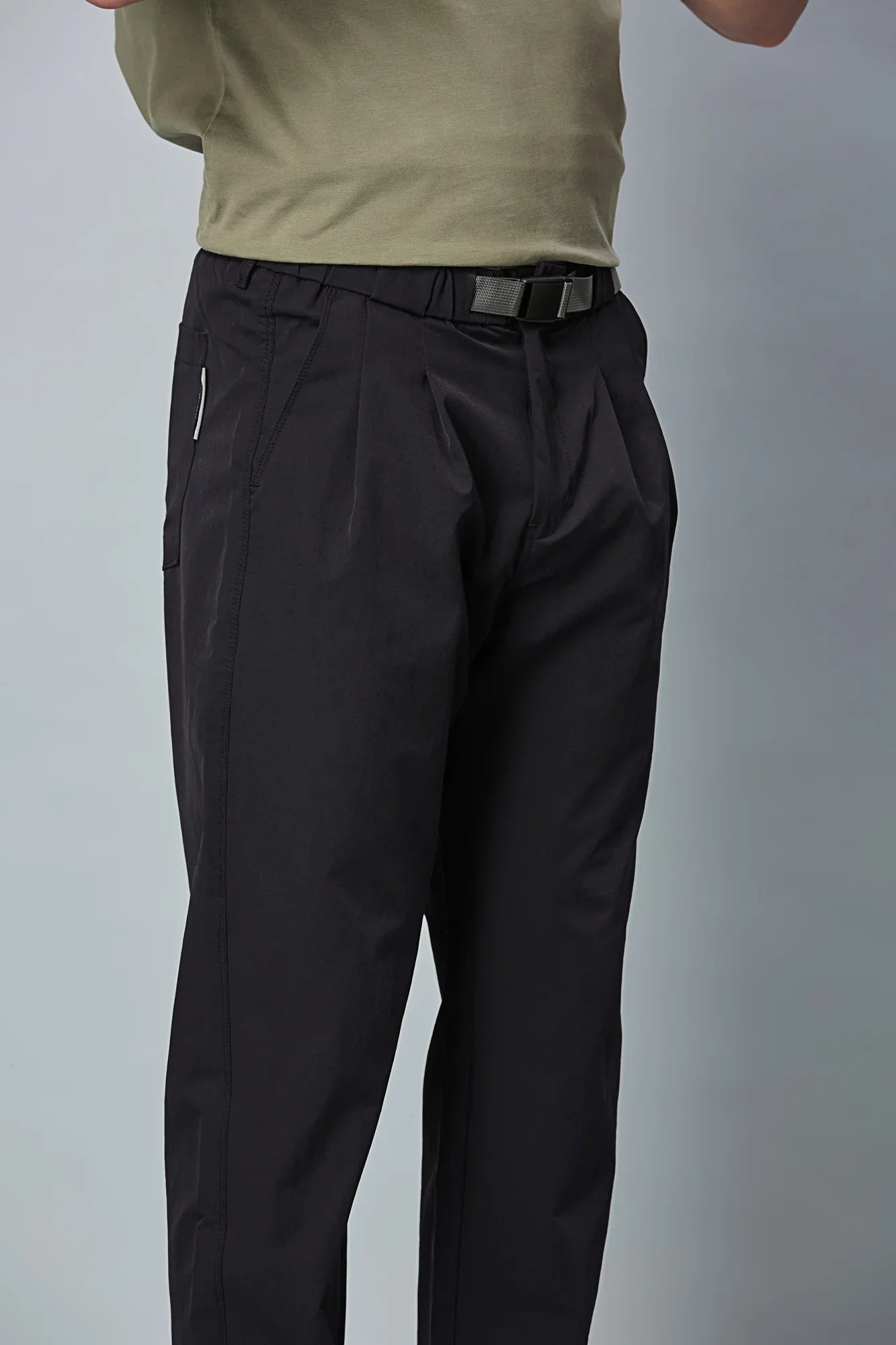 Close-up of Navy Blue trousers belt, elastic waist, and pleated design details