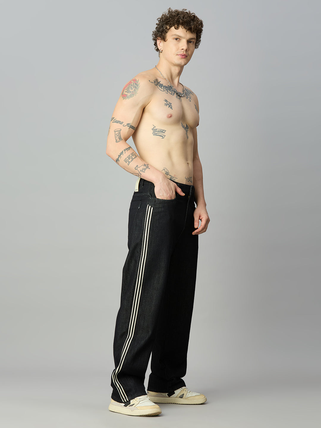 Model wearing The Lofa men's raw black baggy denim jeans with double side stripes for a premium streetwear look