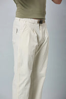 Close-up of beige trousers belt, elastic waist, and pleated design details