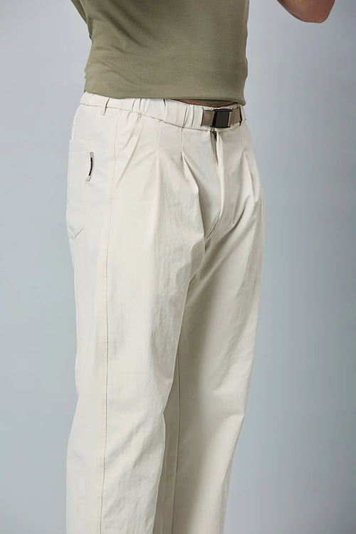 Close-up of beige trousers belt, elastic waist, and pleated design details
