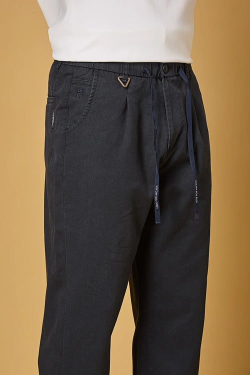 Close-up of navy blue trousers waist string, triangle ring, and fabric texture.