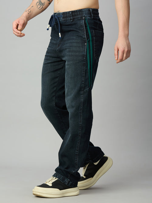 Dark wash baggy denim jeans with green contrast side stripe and drawstring waistband – left side view