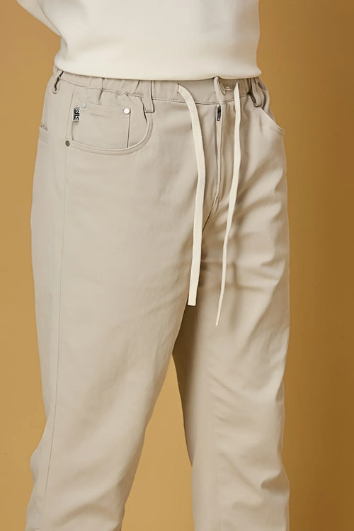 Close-up of beige polyester fabric texture showing smooth and stretchable finish.